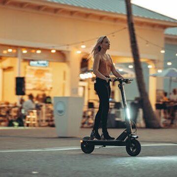 Young person riding a rental e-scooter on a London street