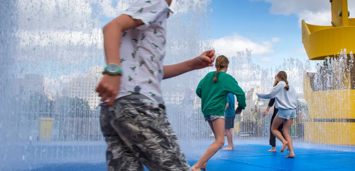 Young kids playing in a. water park, trying to cool down from the UK heat