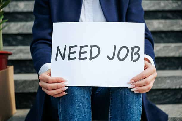 A person holding up a need a job sign. Showcasing the lack of jobs in the UK job market 