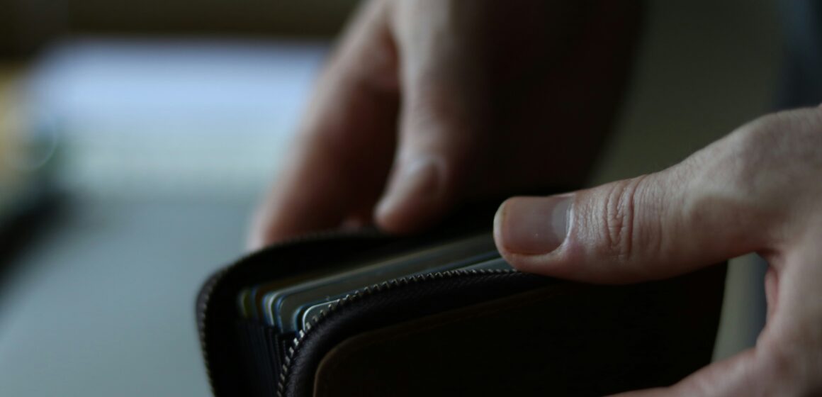 Man opening his wallet with cash in.
