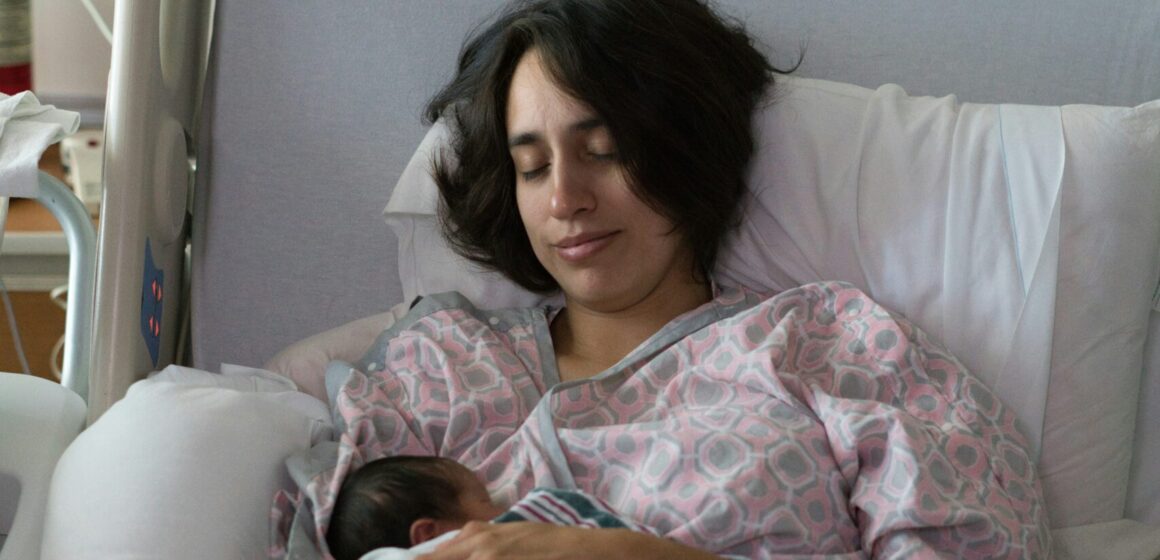 Woman with new born baby in the maternity ward. Photo Credit: Brian Wangenheim on Unsplash