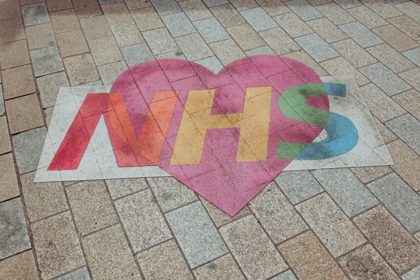 Photograph of the NHS logo painted on the floor with a heart around it.