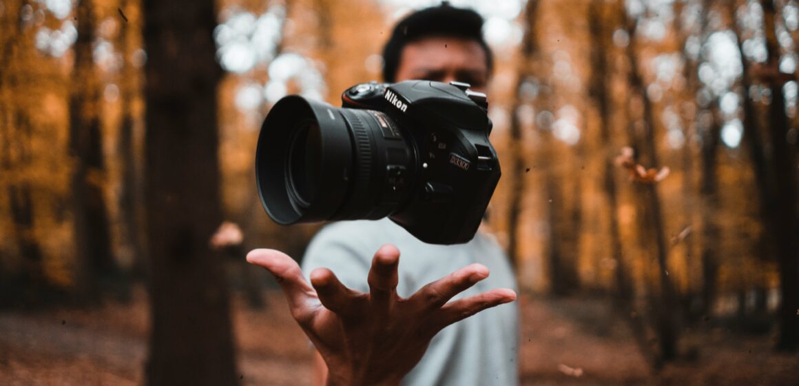 Photograph of a camera floating above someone's hand.