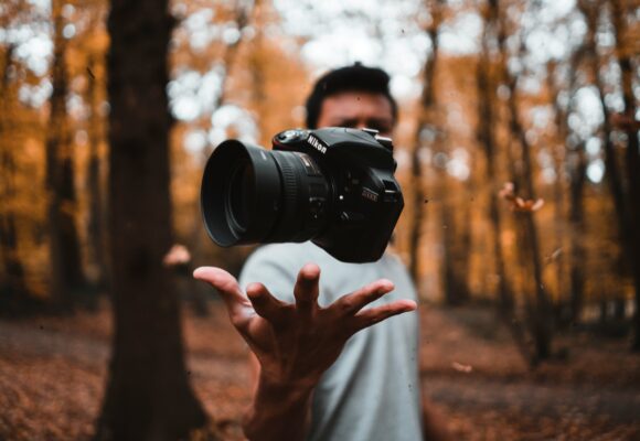 Photograph of a camera floating above someone's hand.