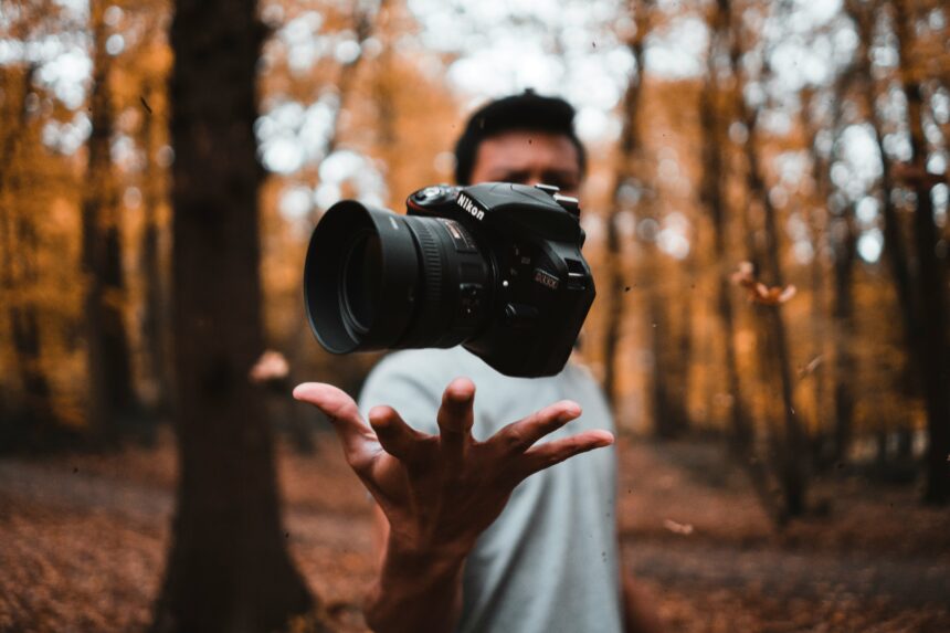 Photograph of a camera floating above someone's hand.