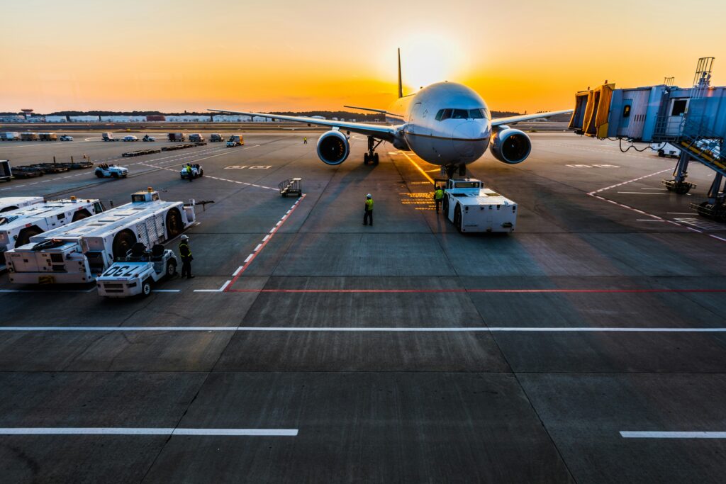Photo of an airport, with a stationary plane preparing to board people.