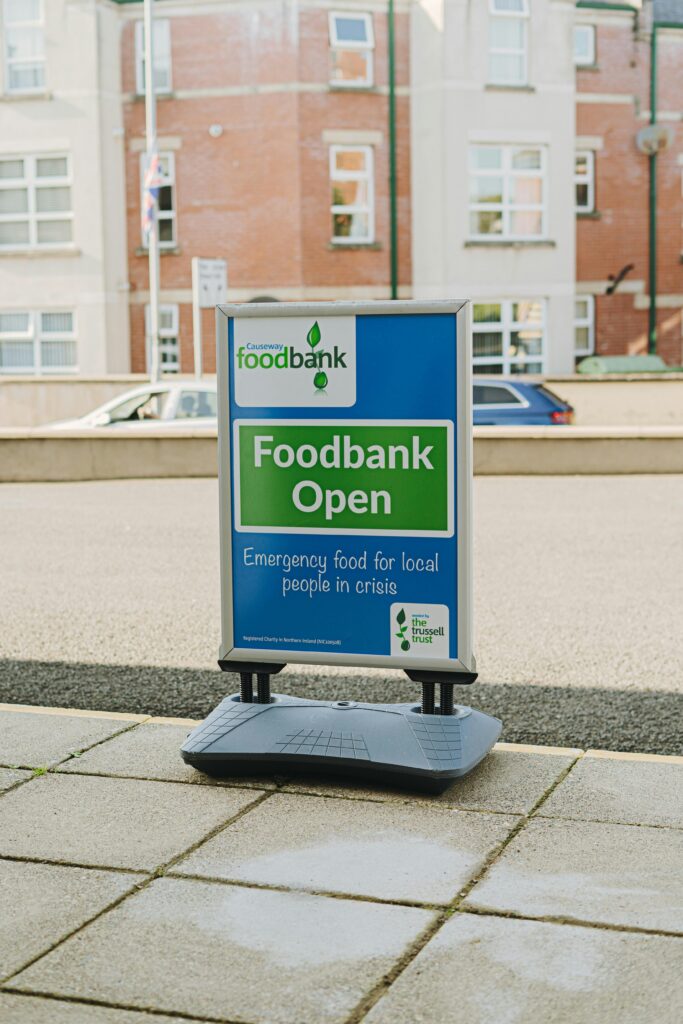 A photograph of a 'foodbank open' sign outside of a supermarket. 