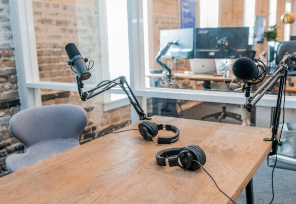 Photograph of an office with a headphone, microphone and camera set up.