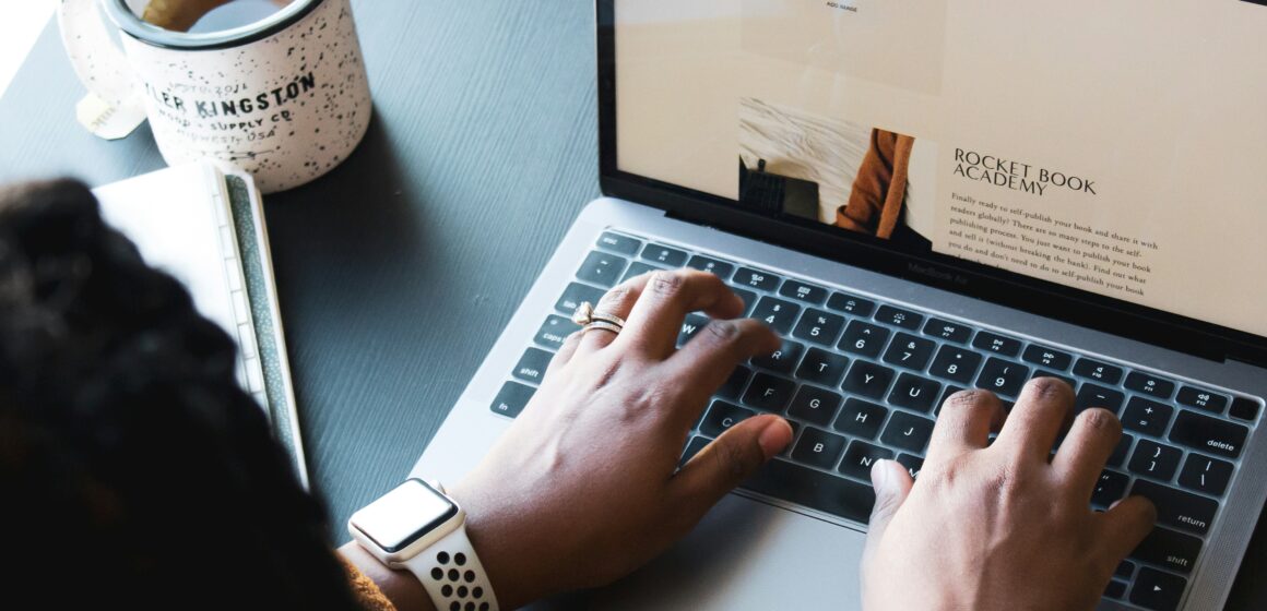 A photograph of someone working on their laptop.