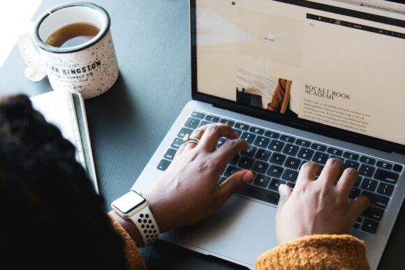 A photograph of someone working on their laptop.
