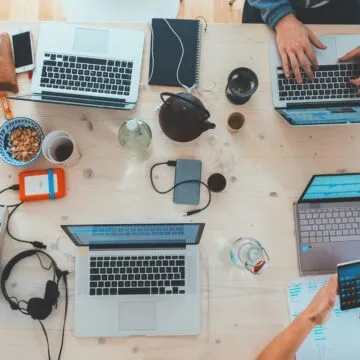 Photopraph of different types of technology. Including laptops, portable chargers, headphones, wires and phones.