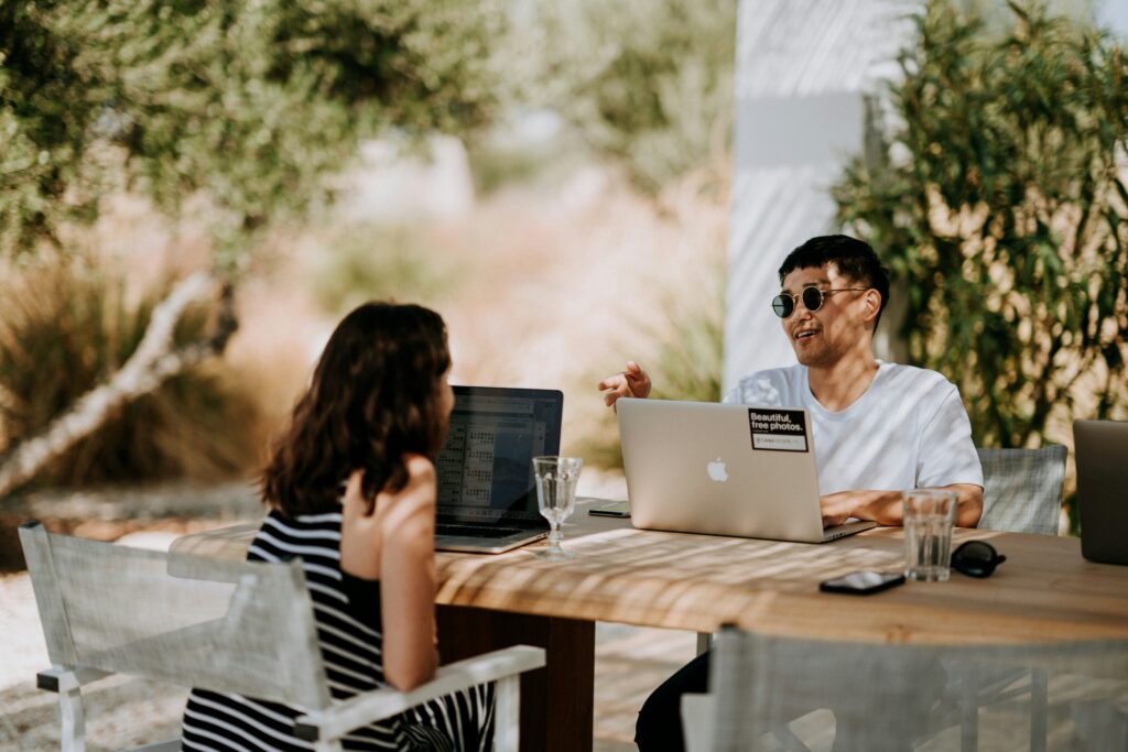Photograph of two colleagues working on their laptops. 