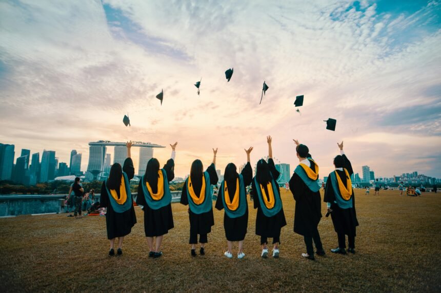 Photograph of university students throwing their graduation hats in the air.