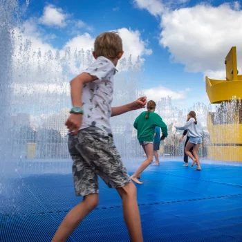 Young kids playing in a. water park, trying to cool down from the UK heat